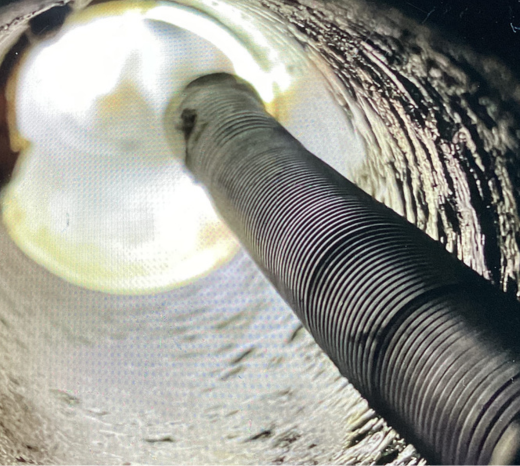 Summary image introducing a blog about trenchless sewer repair. The image shows the interior of a sewer pipe being cleaned out and prepped for repair service.